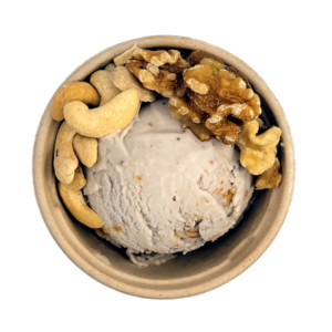 Scoop of banana nut ice cream in cup with ingredients.