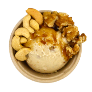 Scoop of maple walnut ice cream in bowl with ingredients.